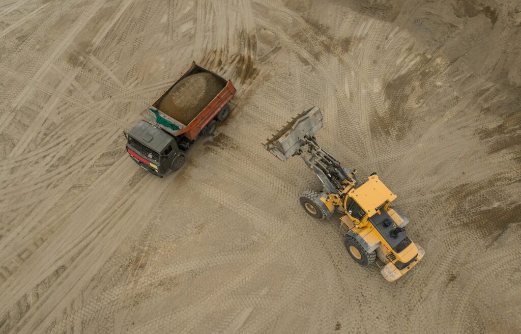 Aerial view of bulldozer pouring sand into truck