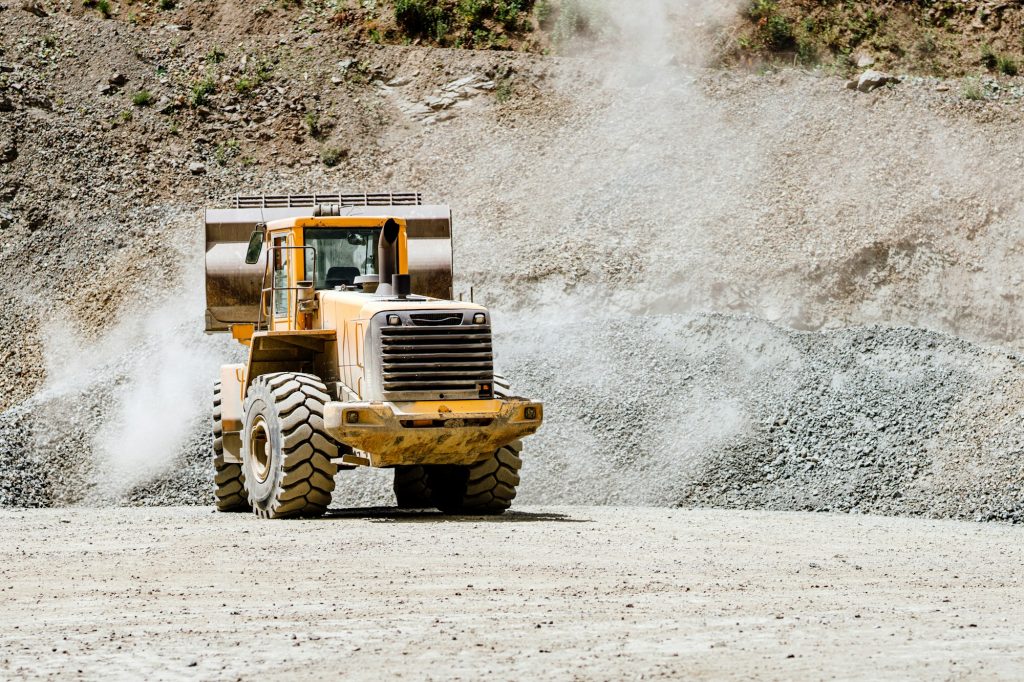 Wheel loader machine loading rocks in the open-mine, iron ore mining.